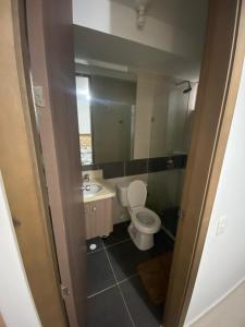 a bathroom with a toilet and a sink and a mirror at Torino Barranquilla- Miramar in Barranquilla +5 photos