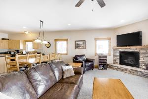 a living room with a leather couch and a fireplace at Take a break in South Fork