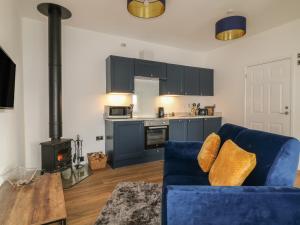 un soggiorno con divano blu e piano cottura di Primrose End a Bude