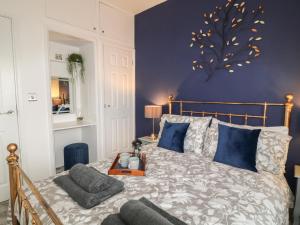 una camera con un letto con una parete blu di Primrose End a Bude