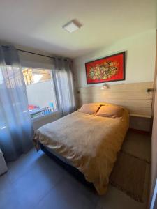 1 dormitorio con cama y ventana. en UMAIN 3 con jardin en San Martín de los Andes