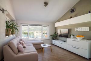 ein Wohnzimmer mit einem Sofa und einem TV in der Unterkunft Kamerlengo in Trogir