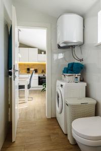 a bathroom with a washing machine and a kitchen at Kamerlengo in Trogir