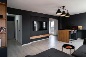 a living room with black walls and a table at Skylark - Manhattan Penthouse with Jacuzzi & Panoramic View in Braşov