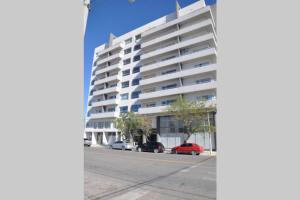 a building on a street with cars parked in front of it at La Amada in Puerto Madryn