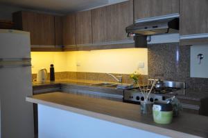 a kitchen with a sink and a stove top oven at La Amada in Puerto Madryn