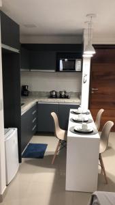 a kitchen with a white table and chairs in it at FLAt COMPLETO BEIRA MAR in Cabedelo