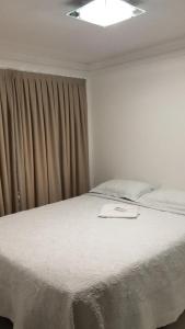 a bedroom with a white bed with a window at FLAt COMPLETO BEIRA MAR in Cabedelo