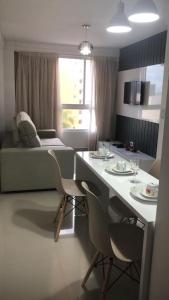 a living room with a table and chairs and a couch at FLAt COMPLETO BEIRA MAR in Cabedelo