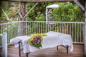 a white table with a bouquet of flowers on it at Hawaii Island Retreat at Ahu Pohaku Ho`omaluhia in Kapaau