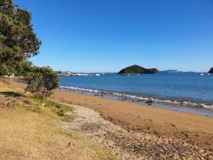 a sandy beach with the ocean in the background at Paihia Apartments in Paihia
