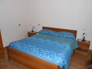 um quarto com uma cama com um edredão azul em La Piaggiola degli Olivi em Panicale
