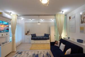 sala de estar con sofá y cama en Portami Al Mare - apartament, terasă & curte, en Mamaia Nord – Năvodari