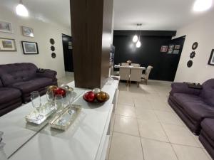 una sala de estar con sofás y una mesa con fruta. en Apartamento alto padrão da praia de Jatiúca/Maceió en Maceió