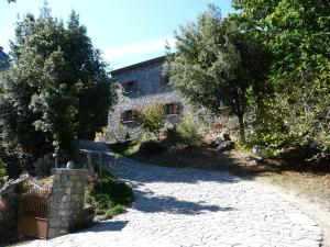 - une vue extérieure sur une maison en pierre avec une allée dans l'établissement Chambre d'Hôte "Chez Antoinette et Charles", à Venaco