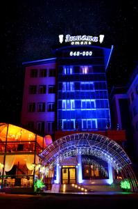 a building with a lit up sign in front of it at Hotel Enigma in Khabarovsk