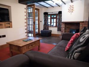 a living room with a couch and a coffee table at Brambles Cottage in Great Malvern