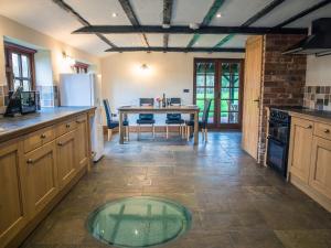 a kitchen with a table in the middle of it at Brambles Cottage in Great Malvern