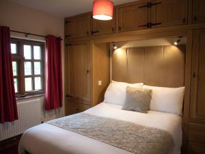 a bedroom with a large bed with a headboard at Brambles Cottage in Great Malvern