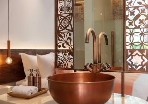 W łazience znajduje się miedziana umywalka i lustro. w obiekcie FCC Angkor by Avani w Siem Reap