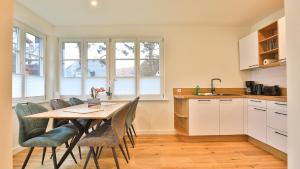 a kitchen with a table and chairs in a kitchen at Traumgarten Haus Traumoase in Prerow