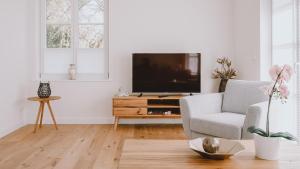 a living room with a television on a wooden table at Traumgarten Haus Leichte Brise in Prerow