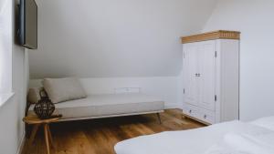 ein Wohnzimmer mit einem Sofa und einem Schrank in der Unterkunft Traumgarten Haus Leichte Brise in Prerow