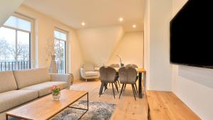 a living room with a couch and a table with chairs at Strandhaus Zingst Apartment 15 in Zingst