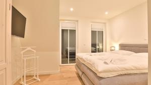 a bedroom with two beds and a flat screen tv at Strandhaus Zingst Apartment 15 in Zingst