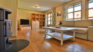 ein Wohnzimmer mit einer Couch und einem Tisch in der Unterkunft Heideröschen Park Heideröschen 5 in Zingst