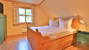 a bedroom with a wooden bed with white pillows at Heideröschen Park Heideröschen 7 in Zingst