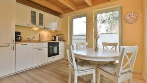 a kitchen with a table and chairs in a kitchen at Heideröschen Park Heideröschen 9b in Zingst
