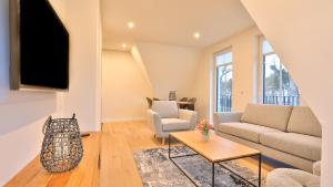 a living room with a couch and a tv at Strandhaus Zingst Apartment 14 in Zingst