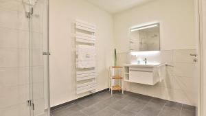 a white bathroom with a sink and a mirror at Strandhaus Zingst Apartment 14 in Zingst +15 photos