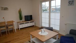 un soggiorno con un tavolo e una tv di Windflüchter Treibholz a Prerow