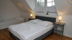 una camera da letto con un letto con due comodini e due lampade di Windflüchter Treibholz a Prerow