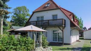 Casa bianca con balcone e ombrellone di Windflüchter Treibholz a Prerow