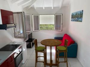 a small kitchen with a table and chairs in a room at PARADIS DES SABLES in Les Galets