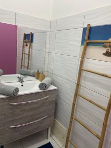 uma casa de banho com uma escada ao lado de um lavatório em PARADIS DES SABLES em Les Galets