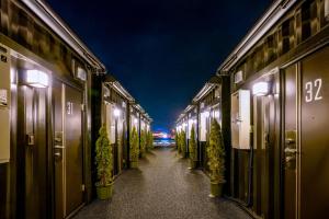 a hallway with potted plants on a street at night at HOTEL R9 The Yard Yaita in Yaita