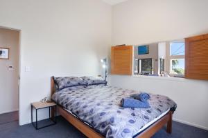 a bedroom with a bed with a blue towel on it at Tuhua Views - Waihi Beach Holiday Home in Waihi Beach