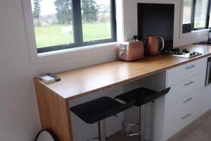a kitchen with a wooden counter and a window at Big View from a Tiny House, Cashmere in Christchurch