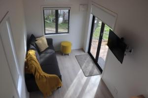 een woonkamer met een bank en een gele deken bij Big View from a Tiny House, Cashmere in Christchurch