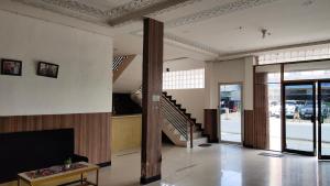 a living room with a couch and a tv and stairs at De' Premium Hotel Musi Raya in Sukarami