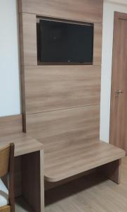 a room with a tv and a desk with a table and a table sidx sidx at Cond VISTA AZUL in Pedra Azul