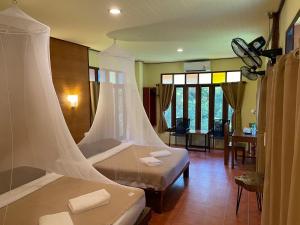 een slaapkamer met 2 bedden en klamboes bij Art's Riverview Lodge in Khao Sok
