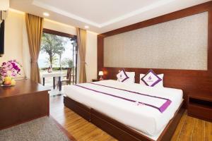 a bedroom with a large bed and a large window at TTC Resort Ninh Thuan in Phan Rang