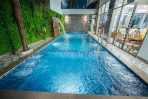贡布Twin Hotel Kampot的建筑物内蓝色水的游泳池