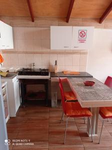 a kitchen with a table and chairs and a stove at Las 2 Golondrinas in El Quisco