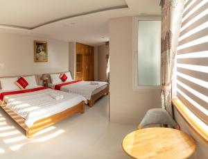 1 dormitorio con 2 camas y ventana en Lam Kiều Hotel en Vung Tau